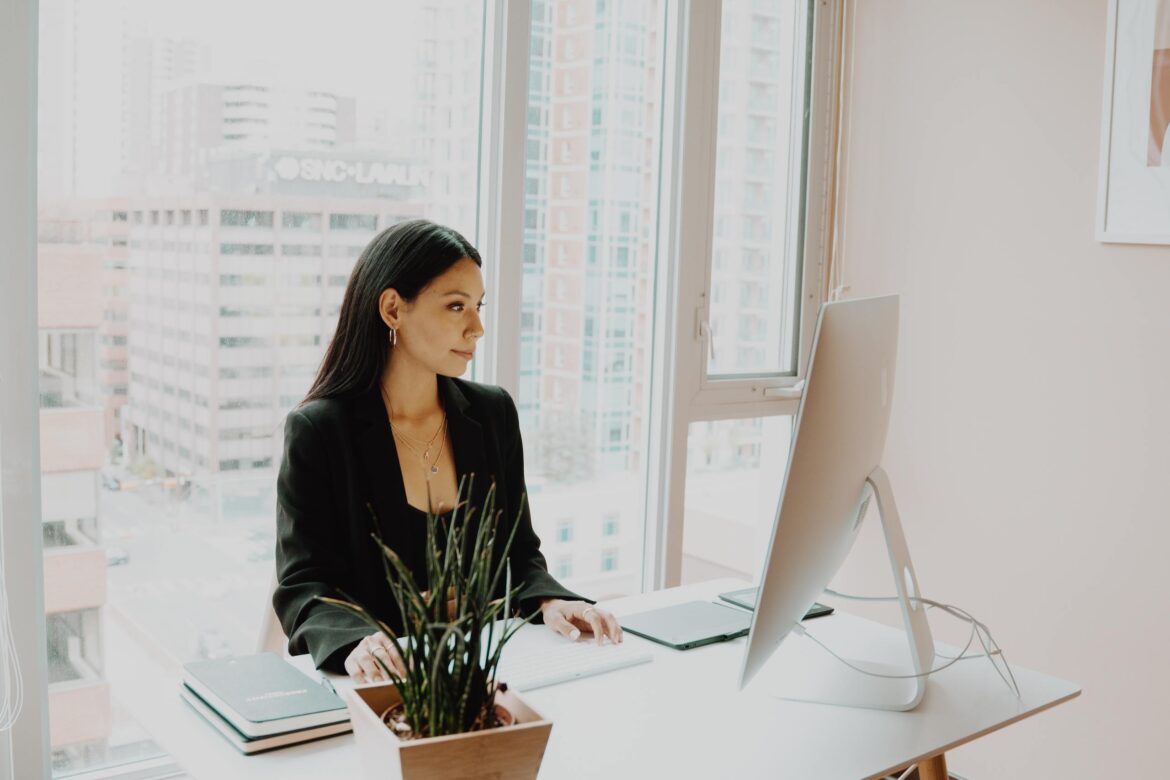 become a mentor, a woman smiling at her laptop