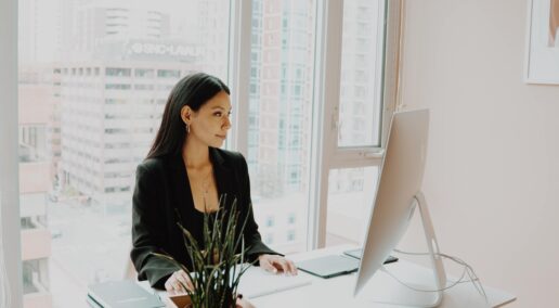 become a mentor, a woman smiling at her laptop